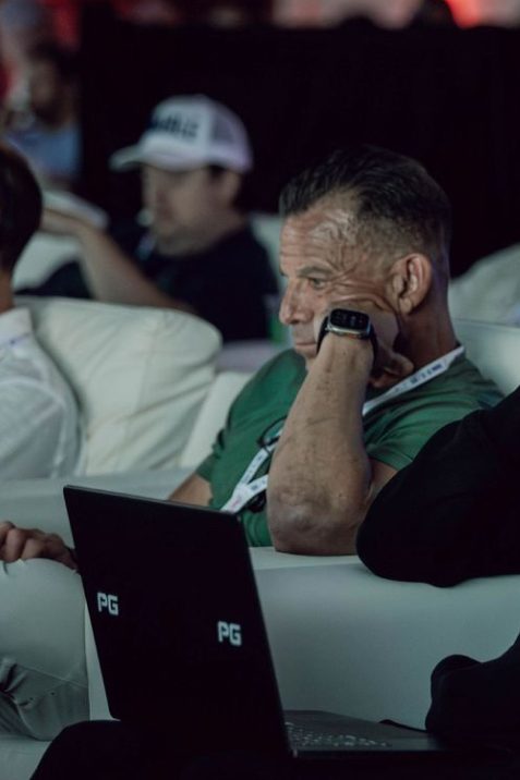 Attendee taking notes on a laptop during a session